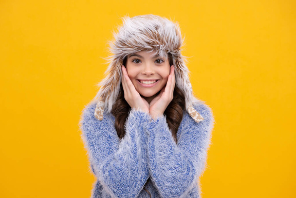 Cappello invernale. Concetto di stagione fredda. Accessori moda inverno per bambini. Teen ragazza indossa caldo cappello a maglia. Ragazza felice viso, emozioni positive e sorridenti - Foto, immagini