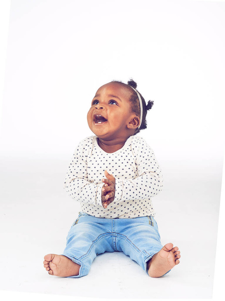 Μ 'αρέσει. Στιγμιότυπο από ένα χαρούμενο κοριτσάκι που κάθεται σε λευκό φόντο - Φωτογραφία, εικόνα
