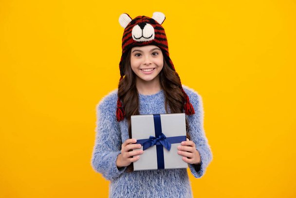 Teenager child with gift box. Present for holidays. Happy birthday, Valentines day, New Year or Christmas. Kid hold present box. Happy teenage girl, positive and smiling emotions - 写真・画像