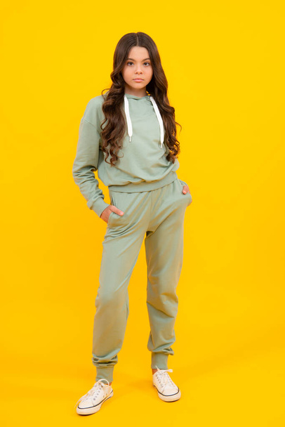 Beautiful teenager child girl in a sports suit, tracksuits. The girl in street sport clothing. Fashion and style, trends. Mockup and copyspace - Foto, Bild