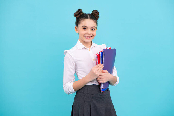 Tiener schoolmeisje met boeken geïsoleerde studio achtergrond. gelukkig tiener, positieve en lachende emoties van tiener meisje - Foto, afbeelding