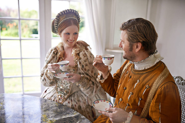 Ποτέ δεν χάνει κανείς το τσάι του. Ένας βασιλιάς και η βασίλισσα πίνοντας τσάι μαζί στο σπίτι - Φωτογραφία, εικόνα