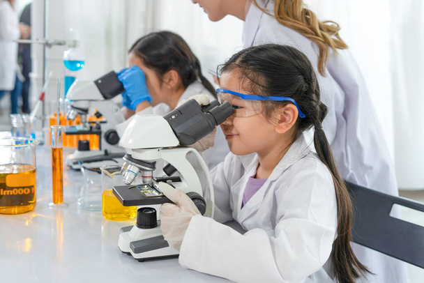 niños estudiando ciencias en laboratorio con una científica como mentora está enseñando a los estudiantes - Foto, imagen