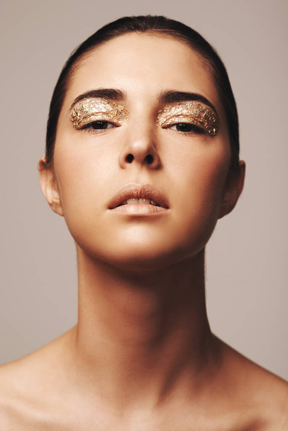 Nascido para brilhar. Estúdio tiro de uma jovem mulher deslumbrante com flocos de ouro em torno de seus olhos - Foto, Imagem