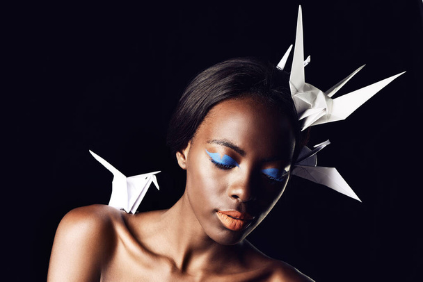 The beauty of Africa. a beautiful ethnic woman posing with origami birds on her head and shoulders - Φωτογραφία, εικόνα