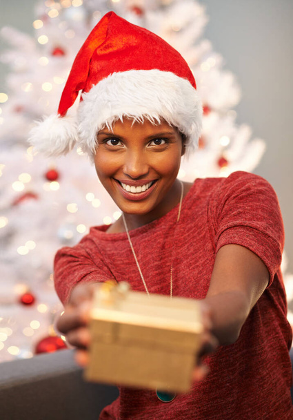This is for you. A beautiful young woman showing one of her Christmas gifts to the camera - Фото, изображение