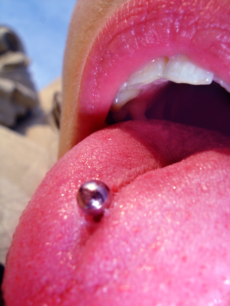 Tongue piercing met een open mond met opvallende kleuren en grote schoonheid van een vrouw - Foto, afbeelding