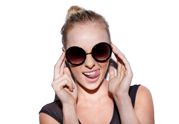 Shes ein unkonventionelles Mädchen. Porträt einer attraktiven jungen Frau mit Sonnenbrille, die verspielt im Studio posiert - Foto, Bild