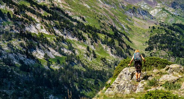 Hiker woman on top of a mountain watching mountainous landscape - Fotografie, Obrázek