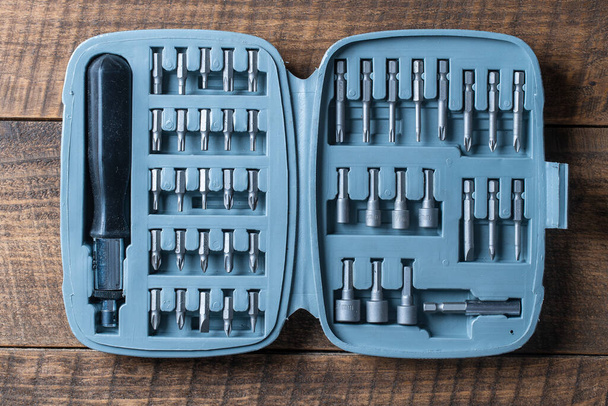 Open set of the interchangeable flat and hexagonal bits different sizes for screwdriver in plastic box. Working tools different types of metal steel heads and bits, Interchangeable screwdriver set. - Фото, изображение