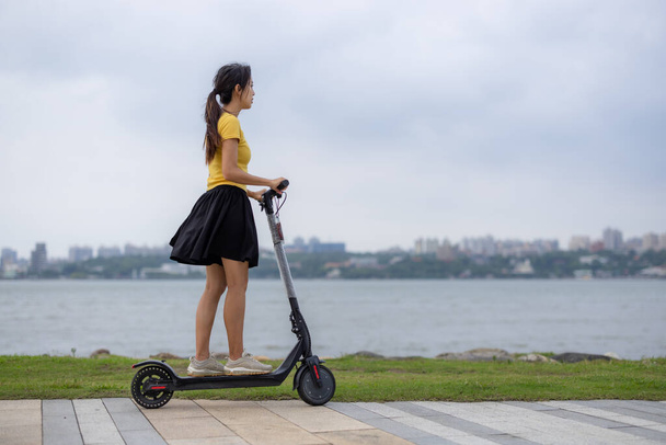 Femme jouer avec scooter moteur dans le parc - Photo, image