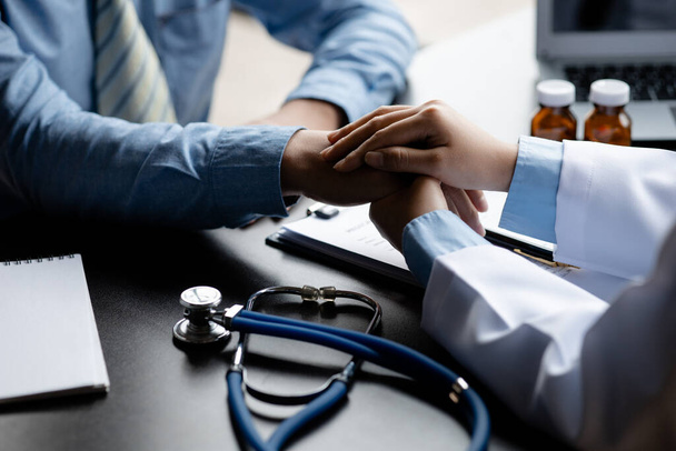 Doctor shook hands to encourage the patient after informing the results of the examination and informing the patients about treatment guidelines and prescribing medicines. Disease examination concept. - Foto, imagen