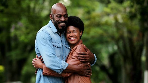 African couple posing outside smiling - Фото, зображення