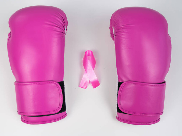 Pink boxing gloves and pink ribbon on a white background. The concept of the fight against breast cancer - Fotó, kép