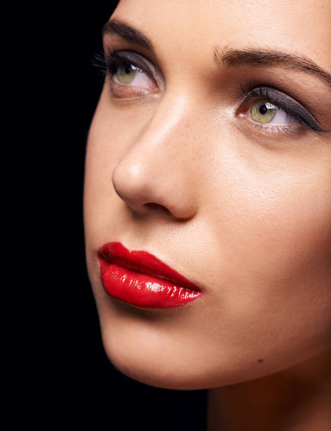 Dama de rojo. Un primer plano de una hermosa joven vestida con lápiz labial rojo, aislada en negro - Foto, Imagen