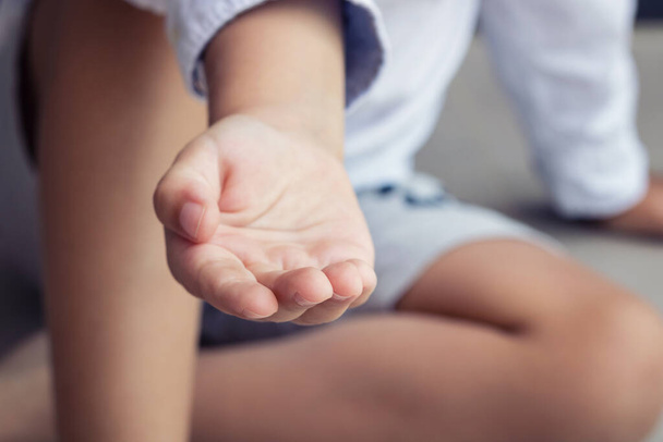 Ręka dziecka sięgająca po pomoc. zbliżenie z dzieckiem proszącym o pomoc.  - Zdjęcie, obraz