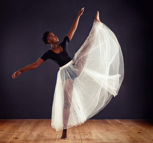 Contemporary perfection. Young female contemporary dancer using a soft white white skirt for dramatic effect - 写真・画像