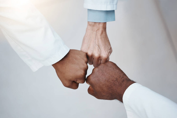 Trust, teamwork and hand fist together in solidarity with medical ethics in the workplace. Support of diverse professional healthcare work people in organization with respect and loyalty - Fotografie, Obrázek