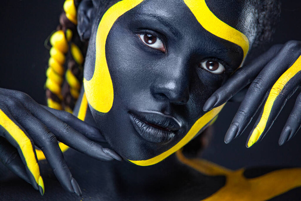 Art fashion makeup. An amazing woman with black makeup and leaking gold paint - Фото, зображення