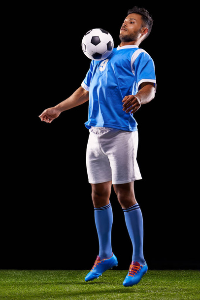 Instant control. Full length studio shot of a handsome young soccer player isolated on black - Fotó, kép