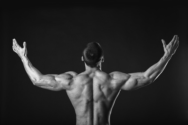 Bodybuilder shows his back muscles. - Фото, изображение