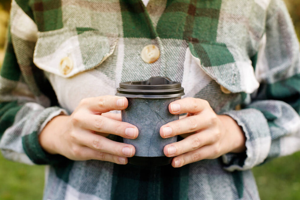 primo piano di caffè per andare con una donna in mano a fare una passeggiata - Foto, immagini