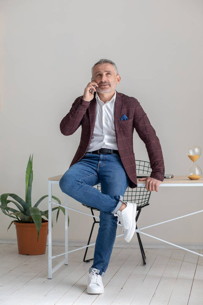 Phone call. Businessman having a phone call and looking involved - Фото, изображение