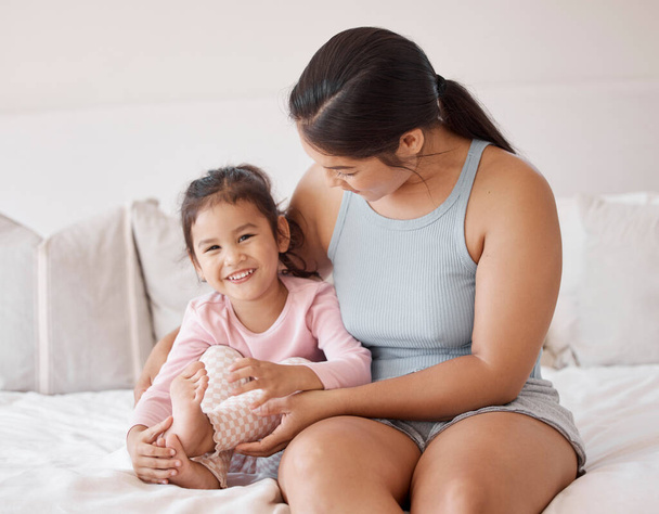 Happy baby and mother in a bedroom portrait for love, support and child care. Excited, relax and happiness of mom holding and bonding with a kid girl for healthy growth child development. - Photo, image