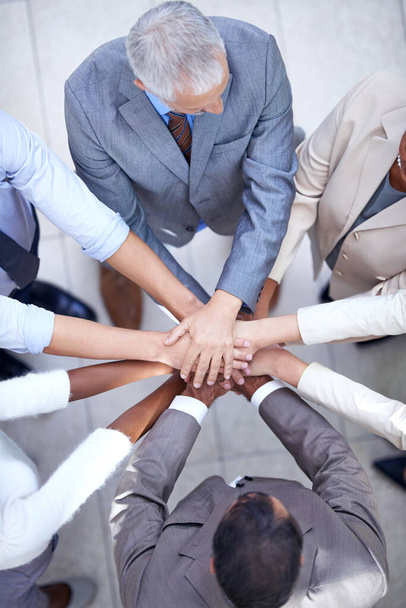 Unidad de negocio. un grupo de compañeros de trabajo con las manos en un grupo - Foto, Imagen