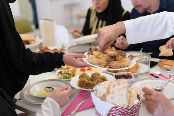 Eid Mubarak Muslim family having Iftar dinner drinking water to break feast. Eating traditional food during Ramadan feasting month at home. The Islamic Halal Eating and Drinking at modern western Isla - Fotó, kép