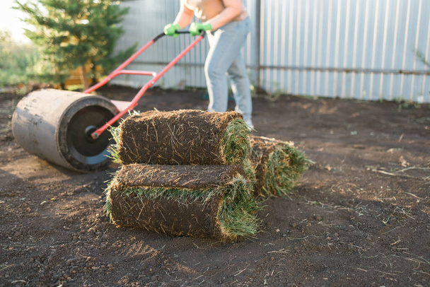 Frau aus nächster Nähe legt Spatenstich für neuen Gartenrasen - Rasenverlegung - Foto, Bild