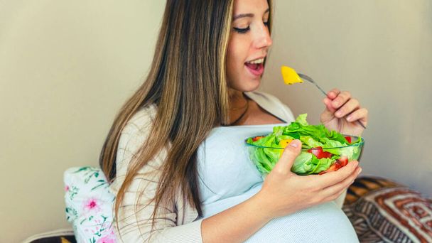 Pregnancy eating healthy salad. Happy pregnant woman eating nutrition food. People lifestyle food concept - Photo, image