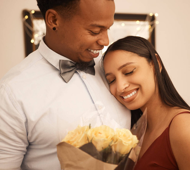 Love, hug and flowers with couple on date for anniversary, valentines day or celebration together. Embrace, gift and happy with young man giving roses to girlfriend in a romantic relationship. - Photo, Image