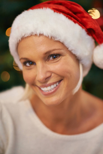 Shes definitely not on the naughty list. a cheerful young woman wearing a christmas hat - Foto, immagini
