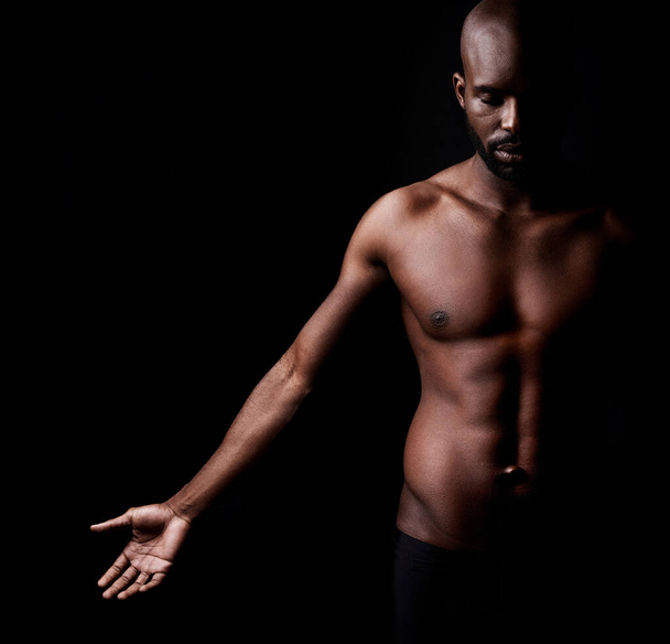 Muscles purs et masculinité. Plan studio d'un homme musclé afro-américain sur fond noir - Photo, image