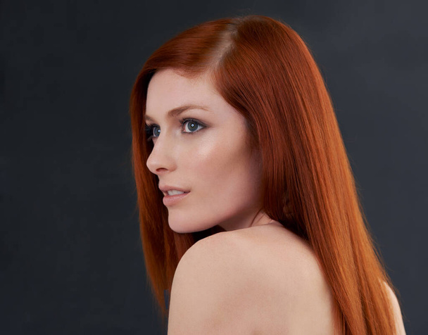 Shes a perfect beauty. Studio shot of a gorgeous young redheaded woman against a black background - Foto, afbeelding
