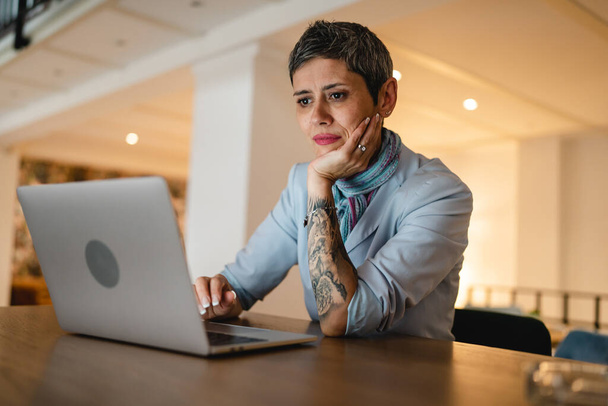 Egy nő érett felnőtt kaukázusi vezető nő ül az asztalnál kávézó dolgozik laptop számítógép távoli online valós emberek másolni tér modern életmód koncepció magabiztos női üzleti vállalkozó - Fotó, kép