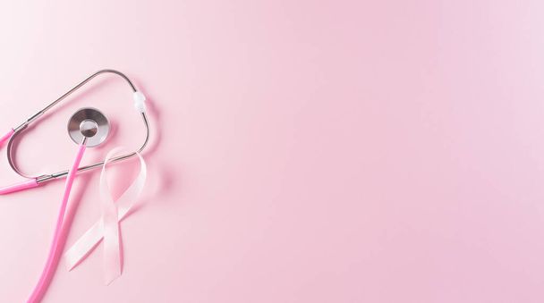 Cintas rosadas y estetoscopio sobre fondo pastel, Símbolo de la conciencia sobre el cáncer de mama femenino, Atención médica y concepto médico. - Foto, Imagen