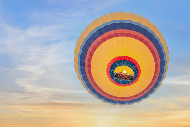view from below of multi color hot air balloon rising up to sky in morning of sunrise - Foto, Bild