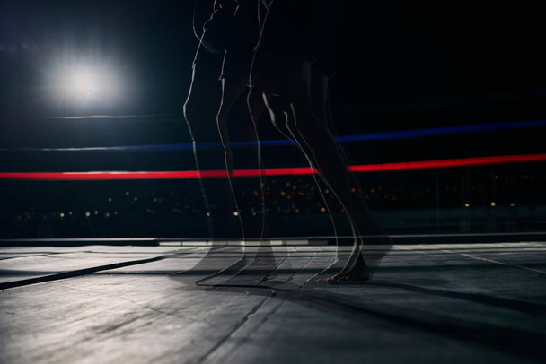 anillo de boxeo, piernas de fitness y boxeador en un partido, torneo o club de lucha. Prizefighter persona muscular caminando o listo para el entrenamiento en una arena oscura para una competición o evento deportivo con maqueta. - Foto, imagen
