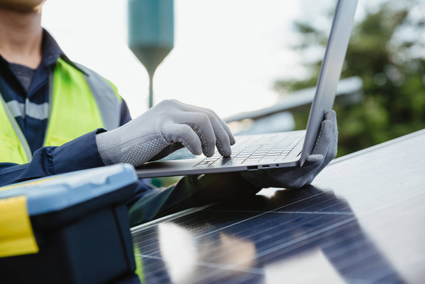 Инженер работает с ноутбуком в солнечных панелях. технология и зеленая экология концепции энергетической системы. - Фото, изображение
