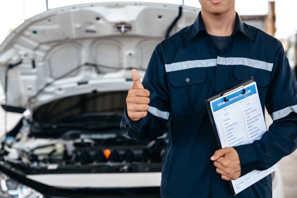 Mechanic working with clipboard insurance inspecting car at garage workshop, Car auto services and maintenance check concept. - Photo, Image
