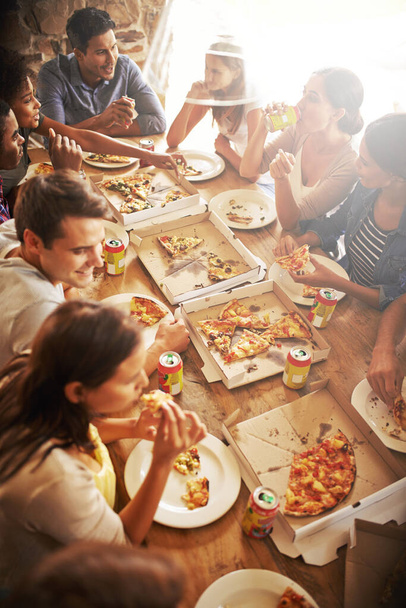 Coge una rebanada y deja que los buenos tiempos rueden. un grupo de amigos disfrutando de la pizza juntos - Foto, imagen