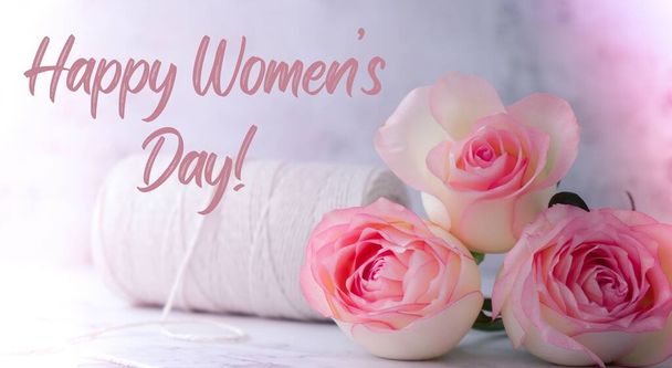 Delicate pink roses with spool of white cotton rope. Minimal trendy composition. Romantic pastel pink rose flowers. Greeting card for HAPPY WOMENS DAY text holiday backdrop poster banner - 写真・画像