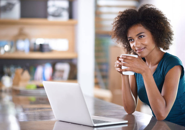 Nautin vapaasta aamusta. viehättävä nuori nainen juo kahvia ja käyttää hänen kannettava tietokone - Valokuva, kuva