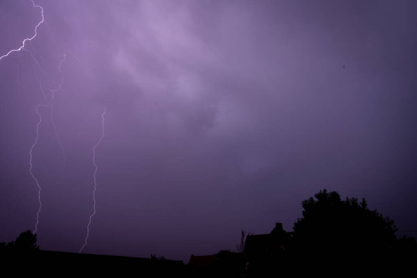 Vista janela de raios sobre as casas em uma área rural em uma noite de verão durante uma tempestade - Foto, Imagem