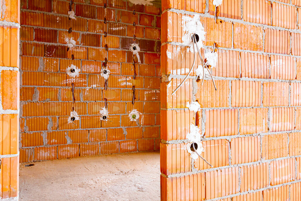 Freiliegende Steckdosen mit entfernten Deckeln für die Montage der Verkabelung an der Wand mit im Bau befindlichen Gebäuden. - Foto, Bild