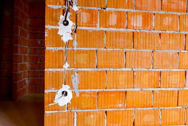 Freiliegende Steckdosen mit entfernten Deckeln für die Montage der Verkabelung an der Wand mit im Bau befindlichen Gebäuden. - Foto, Bild