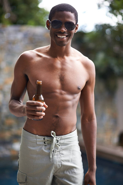 La mejor manera de empezar el verano. Un joven sonriendo a la cámara mientras sostiene una cerveza - Foto, Imagen