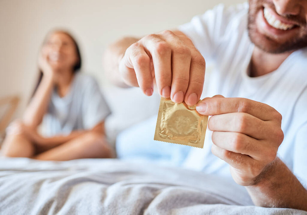Kondomi, sukupuoli ja turvallisuus seksuaalinen pari sängyssä yhdessä onnellinen, hymyillä ja käyttää suojaa. Onnellisuus, rakkaus ja mies ja nainen avoin ehkäisy ehkäisypakkaus suojaamaan std, sti tai hiv. - Valokuva, kuva